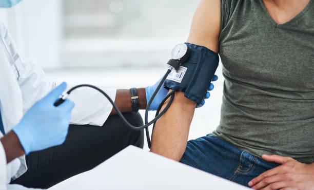 Shot of a doctor examining a man with a blood pressure gauge